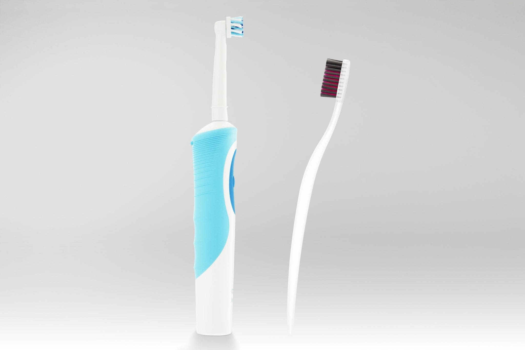 An electric toothbrush and a regular toothbrush