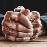 folded hands of elderly person