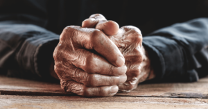 Closeup of the folded hands of an older person. 