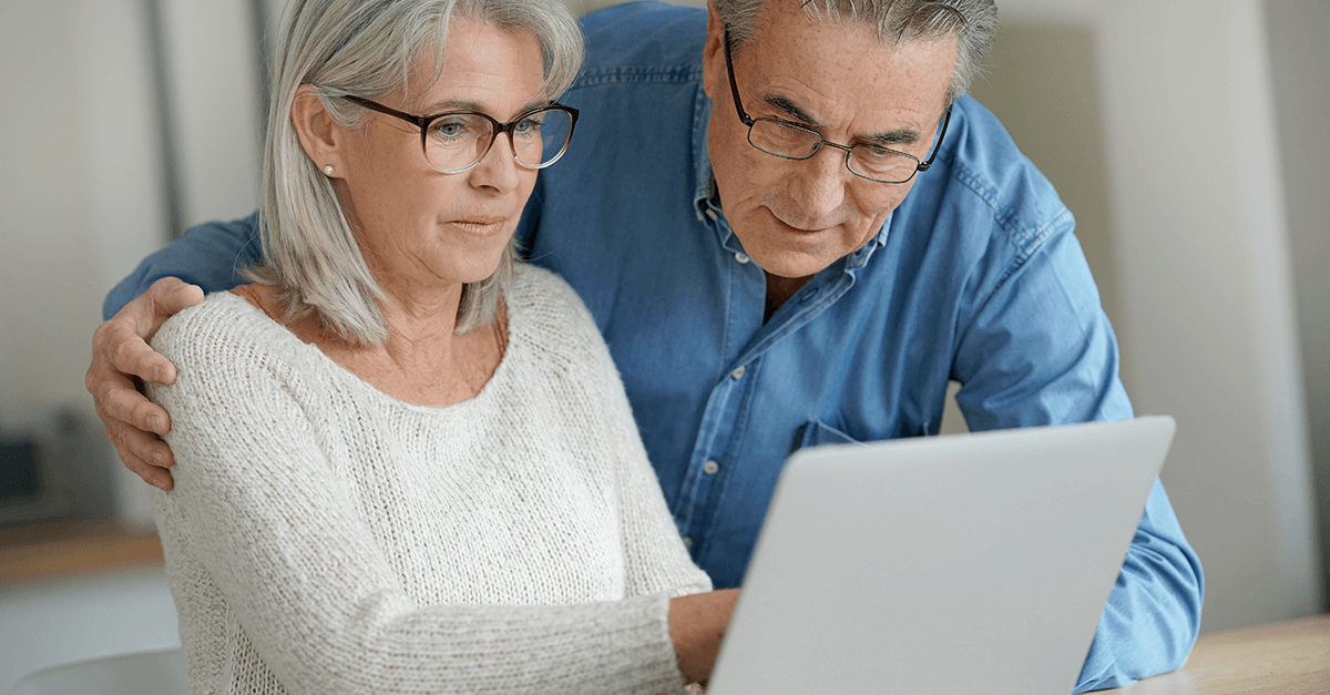 two elderly people looking at a computer
