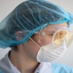 a health care worker wears a face mask