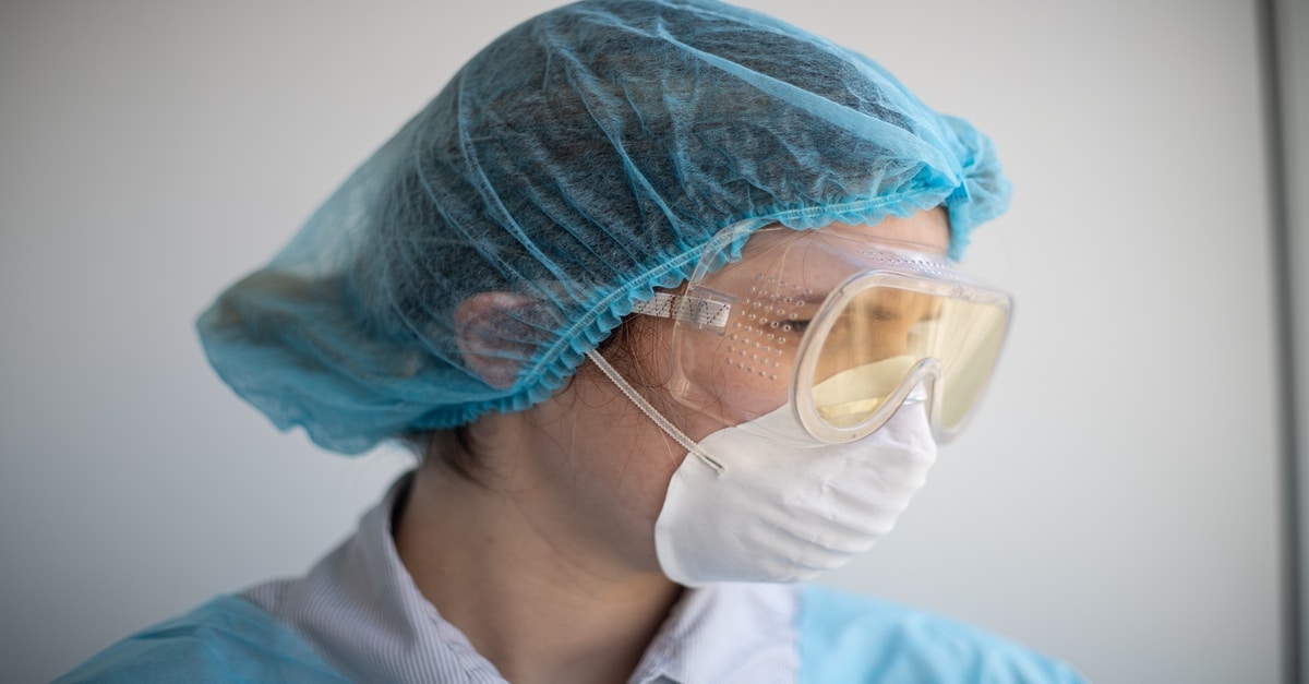 a health care worker wears a face mask