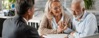an older couple reviews documents with a younger professional