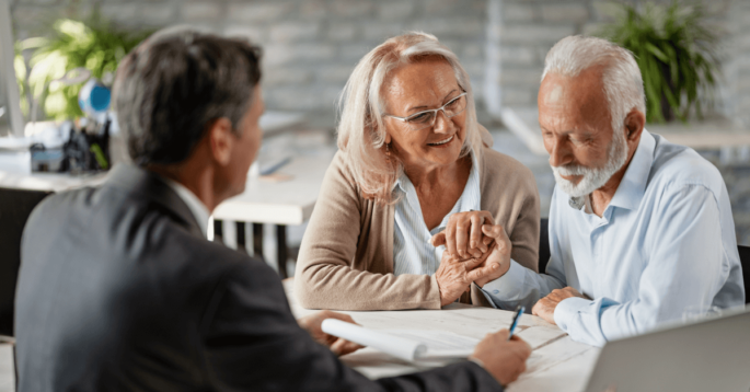 an older couple reviews documents with a younger professional