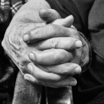 Elderly couple holding hands on chair