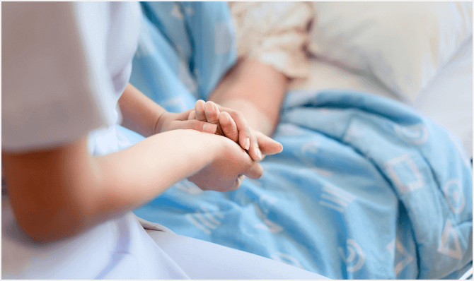 a nurse holds a patient's hand