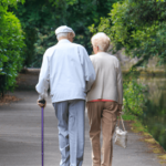 an older couple walking down a path outside