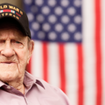 Veteran sits in front of flag