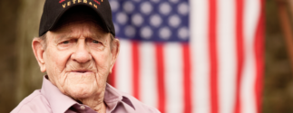 Veteran sits in front of flag