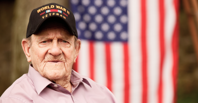Veteran sits in front of flag
