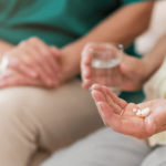 Patient holds medications in hand