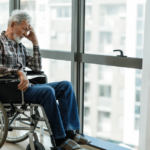 Nursing home resident sits alone at window