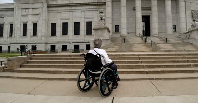 woman in wheelchair in front of court