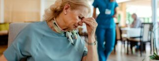 A nursing home resident looking distressed, showing the emotional toll of being forced to leave a care facility