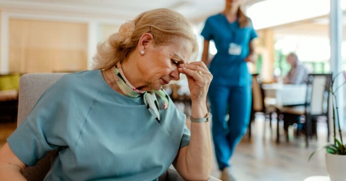 A nursing home resident looking distressed, showing the emotional toll of being forced to leave a care facility