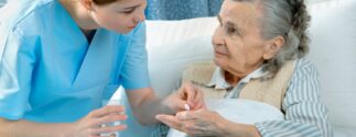 Nurse administering medication to an elderly patient